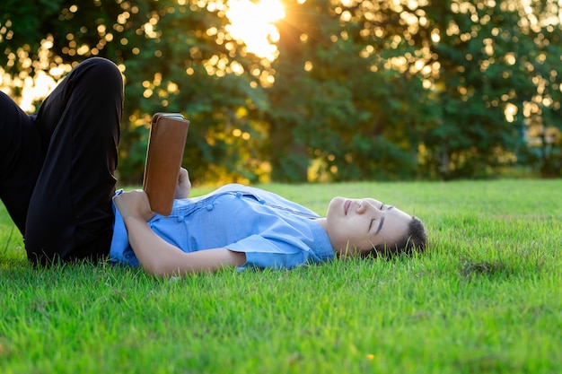 Photo portrait of beautiful young women who relax by watching the tablet in the lawn relax.