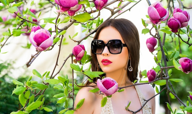 Portrait of beauty model with sunglasses beauty woman face portrait on magnolia blossom