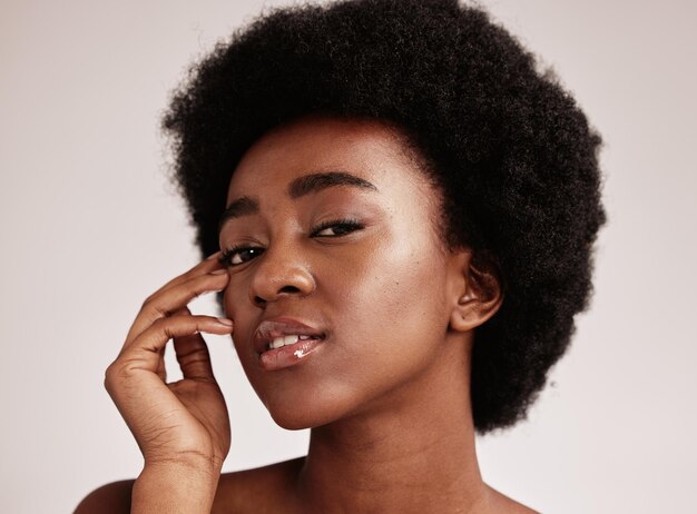 portrait beauty or natural and a model black woman in studio on a gray background with afro hair skin cosmetics and skincare with an attractive young female posing indoor for health or wellness