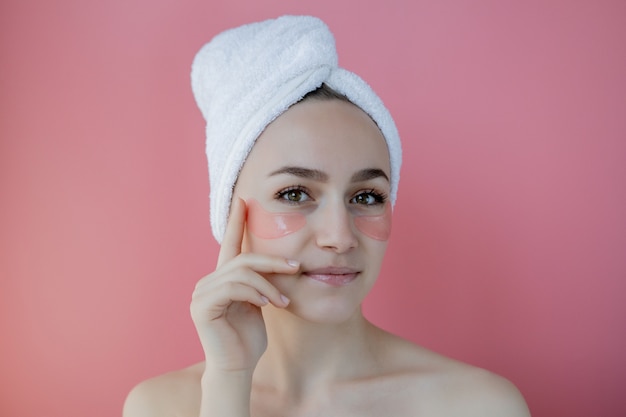 Portrait of Beauty Woman with Eye Patches on pink background. Woman Beauty Face with Mask under Eyes.