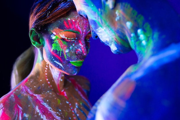 Portrait of a beefy man and woman painted in ultraviolet powder\
body art glowing in ultraviolet