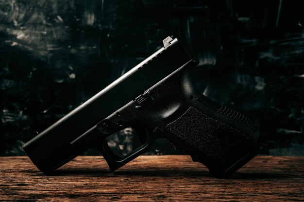 오래된 나무 바닥에 있는 검은색 9mm 권총의 초상화