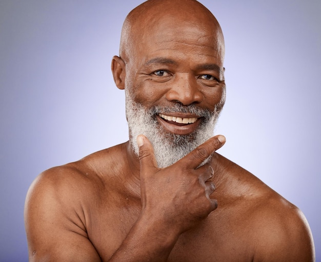 Portrait black man and facial skincare in studio for personal hygiene clean face and natural cosmetics on grey background Happy guy mature male beauty and wellness spa for body care in Nigeria