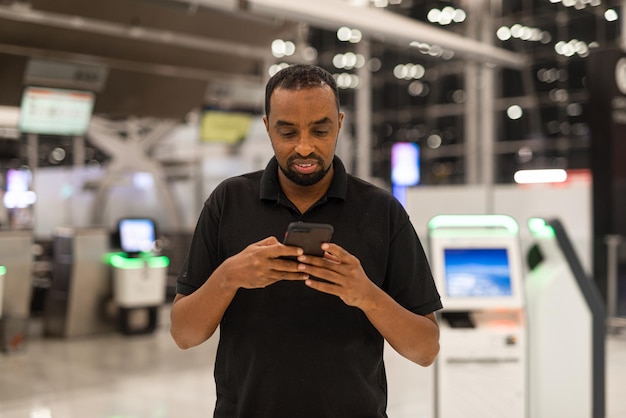 Portrait of black man ready to travel at airport terminal waiting for flight