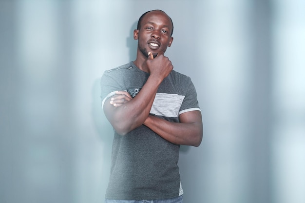 Portrait of a black man with his arms crossed on a gray background