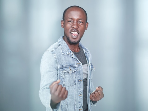 Portrait of a black man with his arms crossed on a gray background