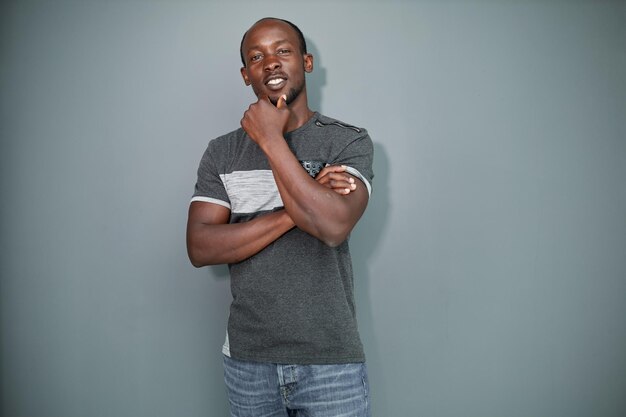 Portrait of a black man with his arms crossed on a gray background