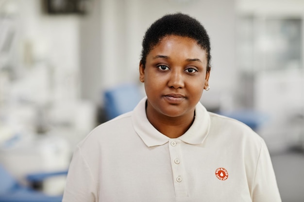 Portrait of black young woman standing in blood donation center with save life sticker on chest and