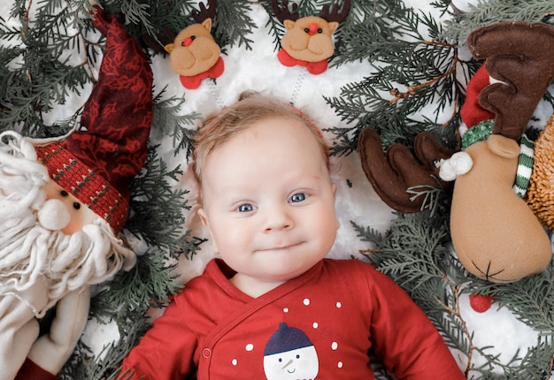 Photo portrait of a blond baby with christmas toys