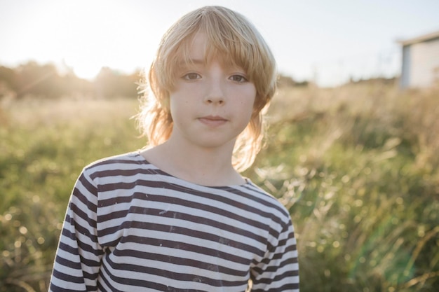 Portrait of blond boy at backlight