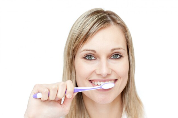 Photo portrait of a blond woman brushing her teeth