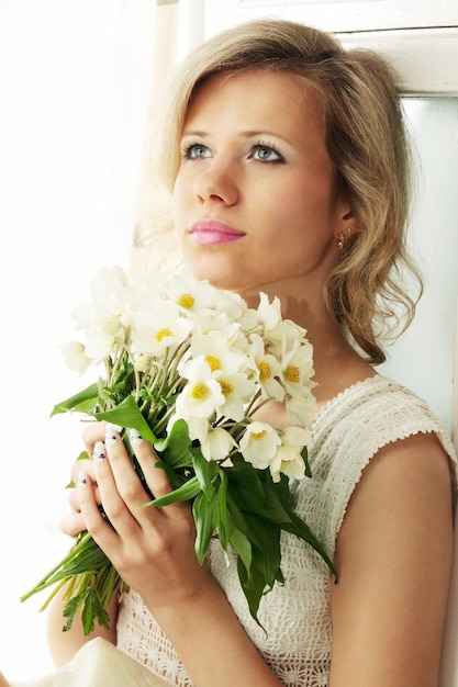 Portrait of blond woman with a bunch of hellebore