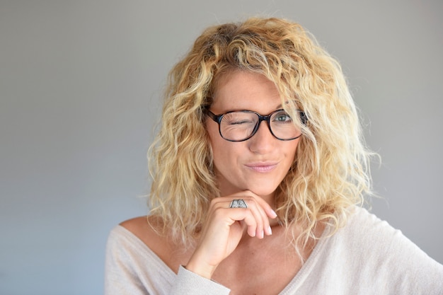 Portrait of blond woman with eyeglasses being expressive