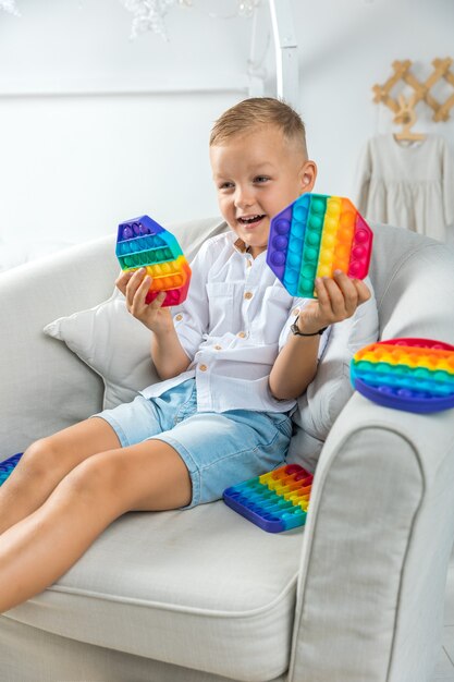 portrait blonde boy with pop it sensory toy different forms