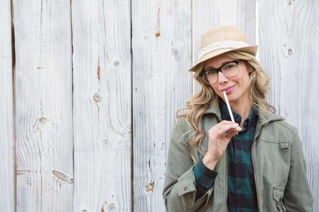 Portrait of blonde in hat posing and holding 