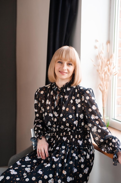 Portrait of blonde woman 35 years old in dress indoor