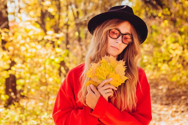 Ritratto di una donna bionda nella foresta di autunno