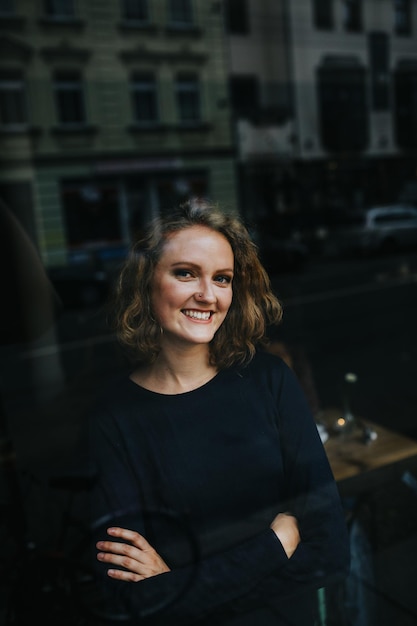 Portrait of blonde woman smiling photographed through store window