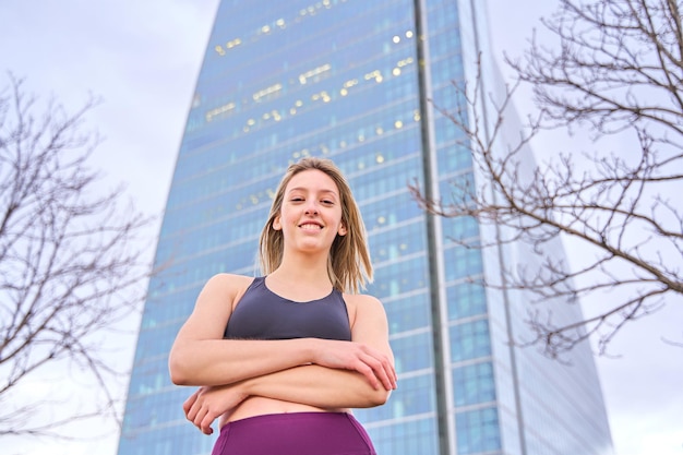 Portrait of a blonde woman in sportswear with skyscrapers in the background