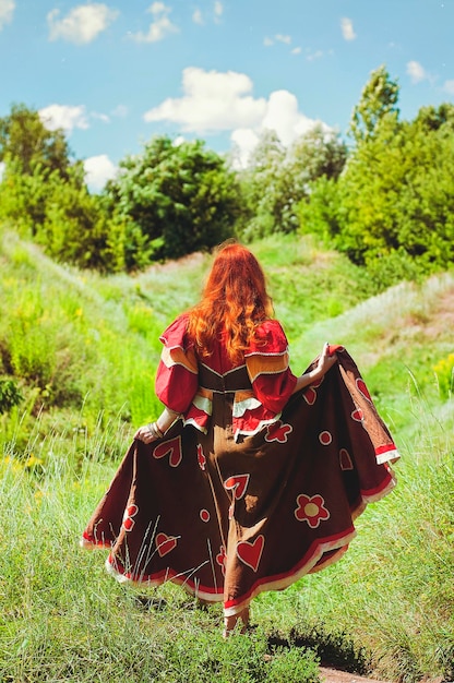 여름 시골에서 걷고, 춤을 추는 보헤미안 빨간 머리 곱슬머리 여자의 초상화, 공원. 행복한 라이프 스타일.