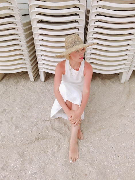 Portrait of boho woman wearing straw hat and fashionable summer clothes posing on the beach Sunset or Sunrise Relax