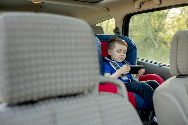 Portrait of a bored little boy sitting in a car seat Safety of transportation of children