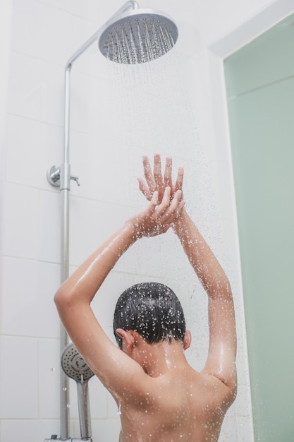 Portrait of a boy bathing using shower in the bathroom