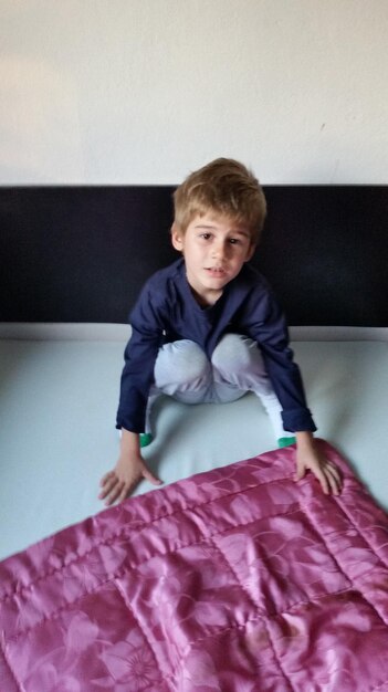 Portrait of boy on bed at home