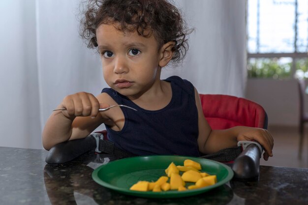 Photo portrait of boy eating food at home