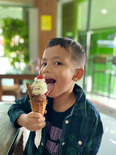 Foto ritratto di un ragazzo che mangia un cono di gelato