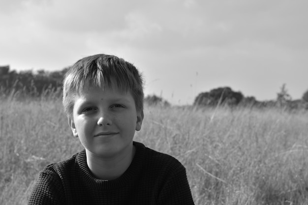 Foto ritratto di un ragazzo sul campo contro il cielo