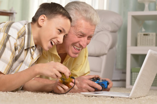 Portrait of boy and grandfather playing computer game