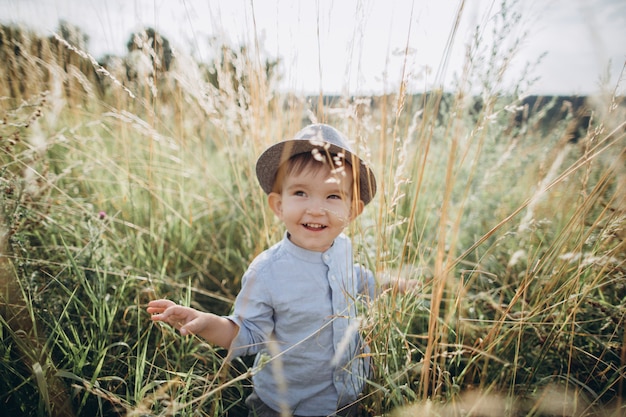 Photo portrait of a boy in a hat on the meadow