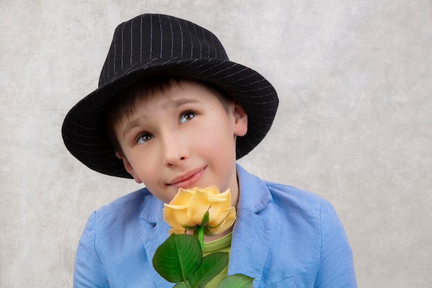 Portrait of a boy in a hat and suit with a rose
