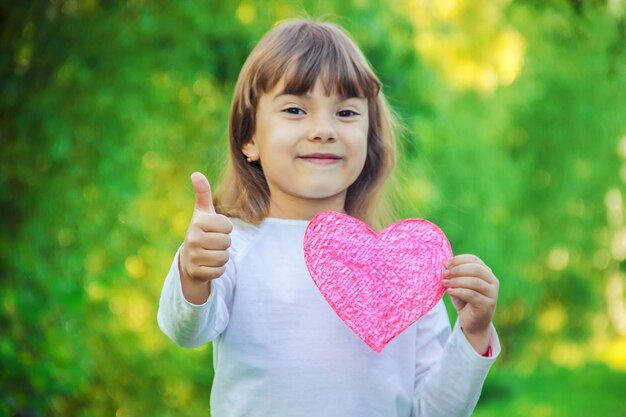 Photo portrait of boy holding heart shape