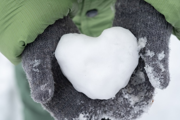 Portrait of a boy holding a heart in the winter