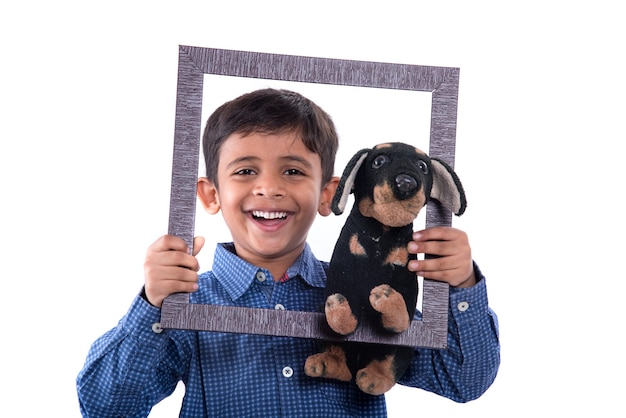 Portrait of a boy holding stuffed toy pet with frame on a white background