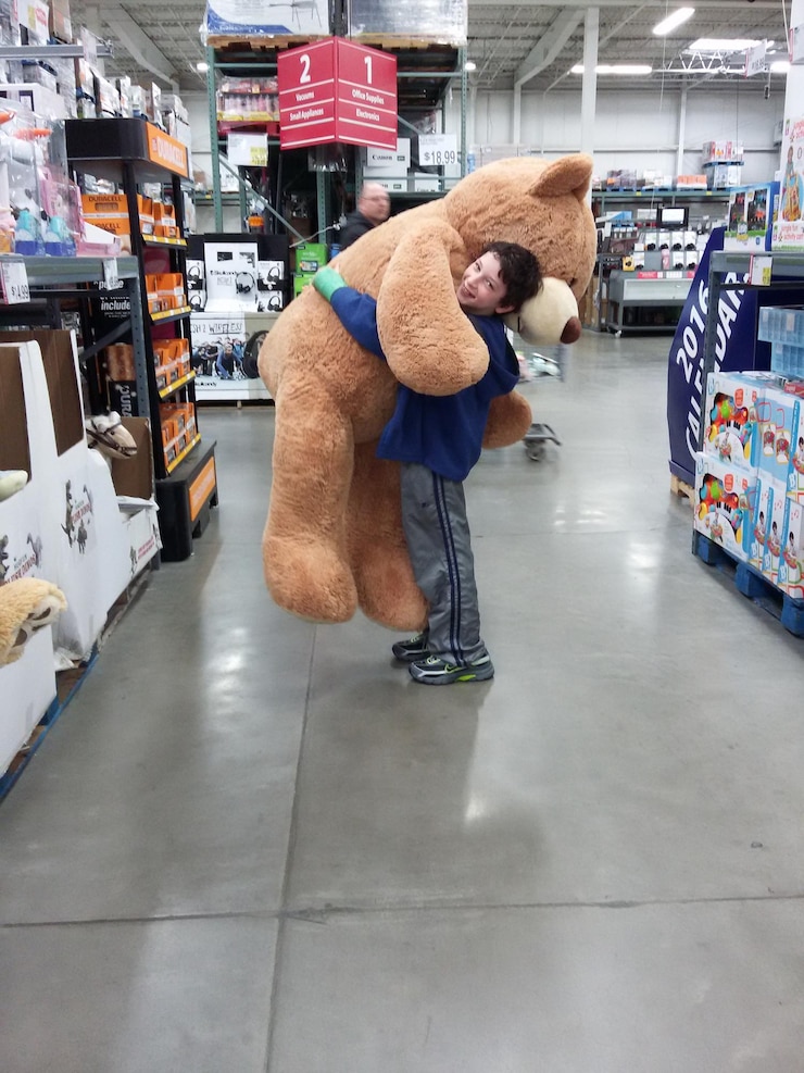 Photo portrait of boy holding teddy bear at store