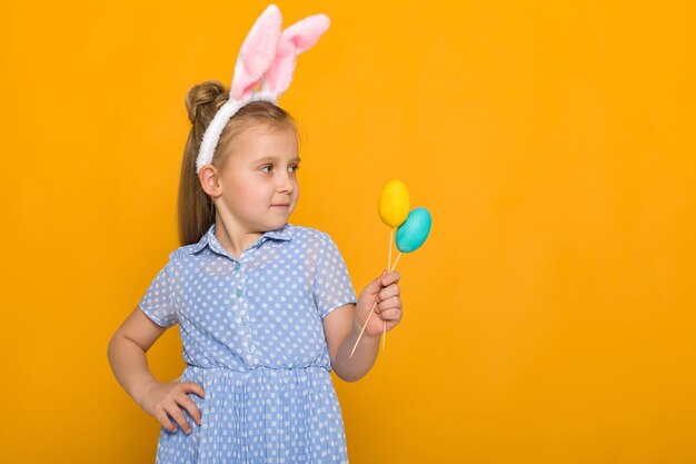 Portrait of boy holding toy against yellow background