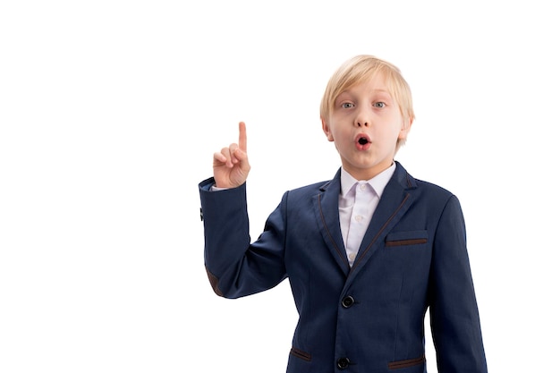 Portrait of boy i school uniform in isolation on white background Schoolboy have idea and he raised index finger up Copy space