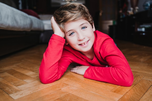 Portrait of boy lying on floor at home