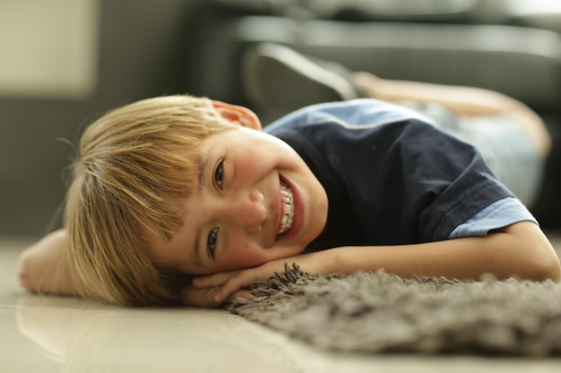 Portrait of boy lying on floor at home