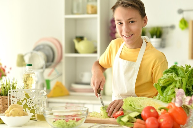 Ritratto di ragazzo che prepara la cucina a casa