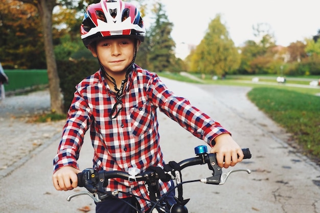 portrait of boy riding bicycle on road