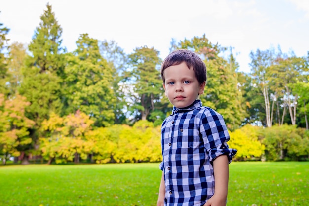 Portrait of a boy in a shirt on the street. Beautiful boy. Little boy. Walk. A child's smile.