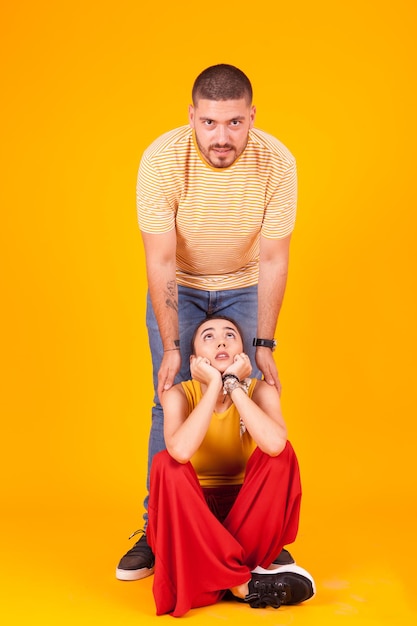 Portrait of boy sitting against yellow background