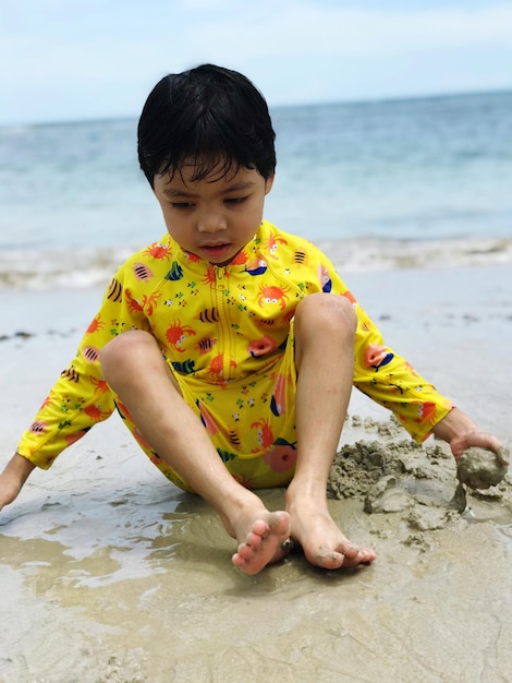 Foto ritratto di un ragazzo seduto sulla spiaggia
