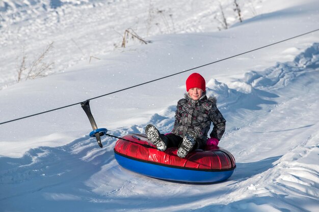 Portrait of boy sitting in inflatable ring on snow covered land