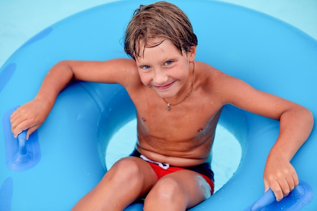 Portrait of boy sitting on inflatable ring