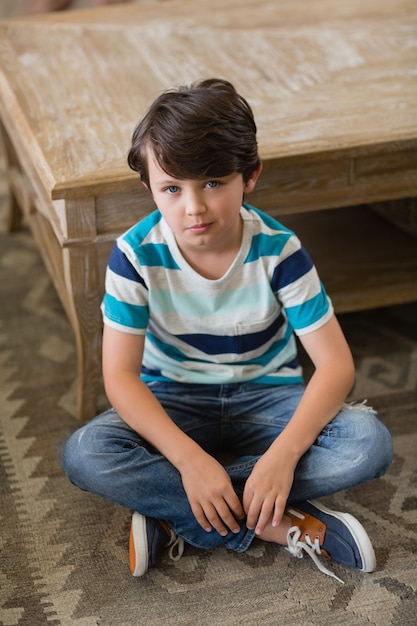 Photo portrait of boy sitting in living room